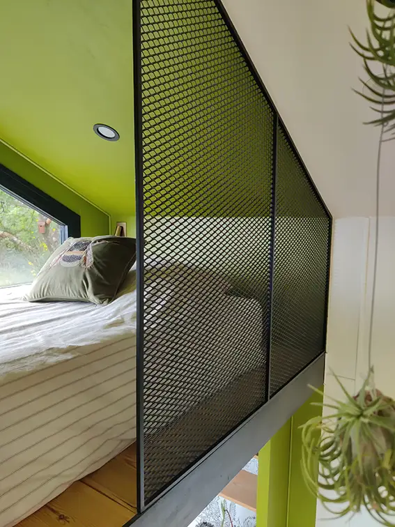 Aménagement intérieur d'une tiny house. Couchette mezzanine simple et son garde corps en métal déployé réalisé sur mesure par nos soins.