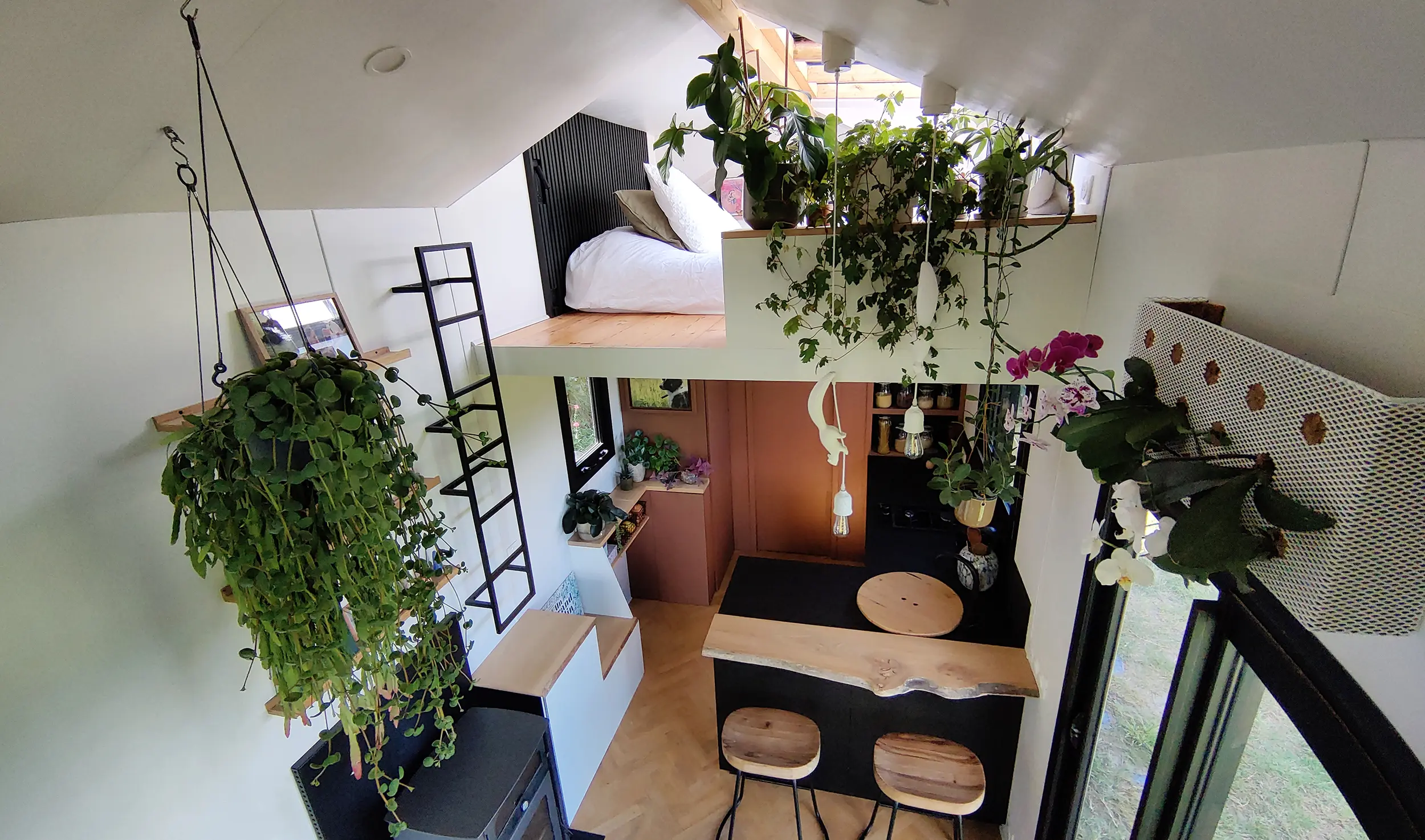 Aménagement intérieur d'une tiny house. Vue de haut et d'ensemble de l'espace cuisine, mezzanine double.