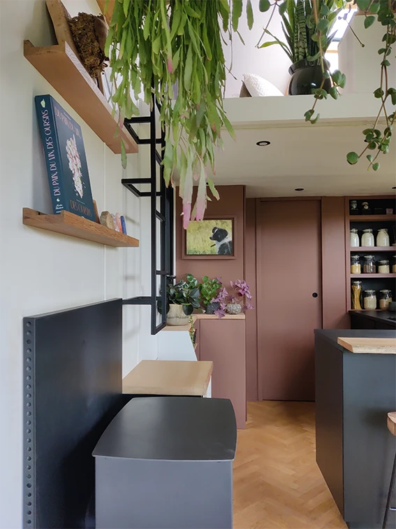 Aménagement intérieur d'une tiny house. Vue vers cuisine et poêle à bois.