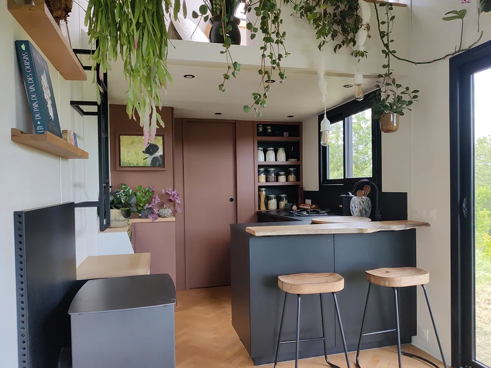 Aménagement intérieur d'une tiny house. Photographie de l'espace cuisine et de son plan bar.